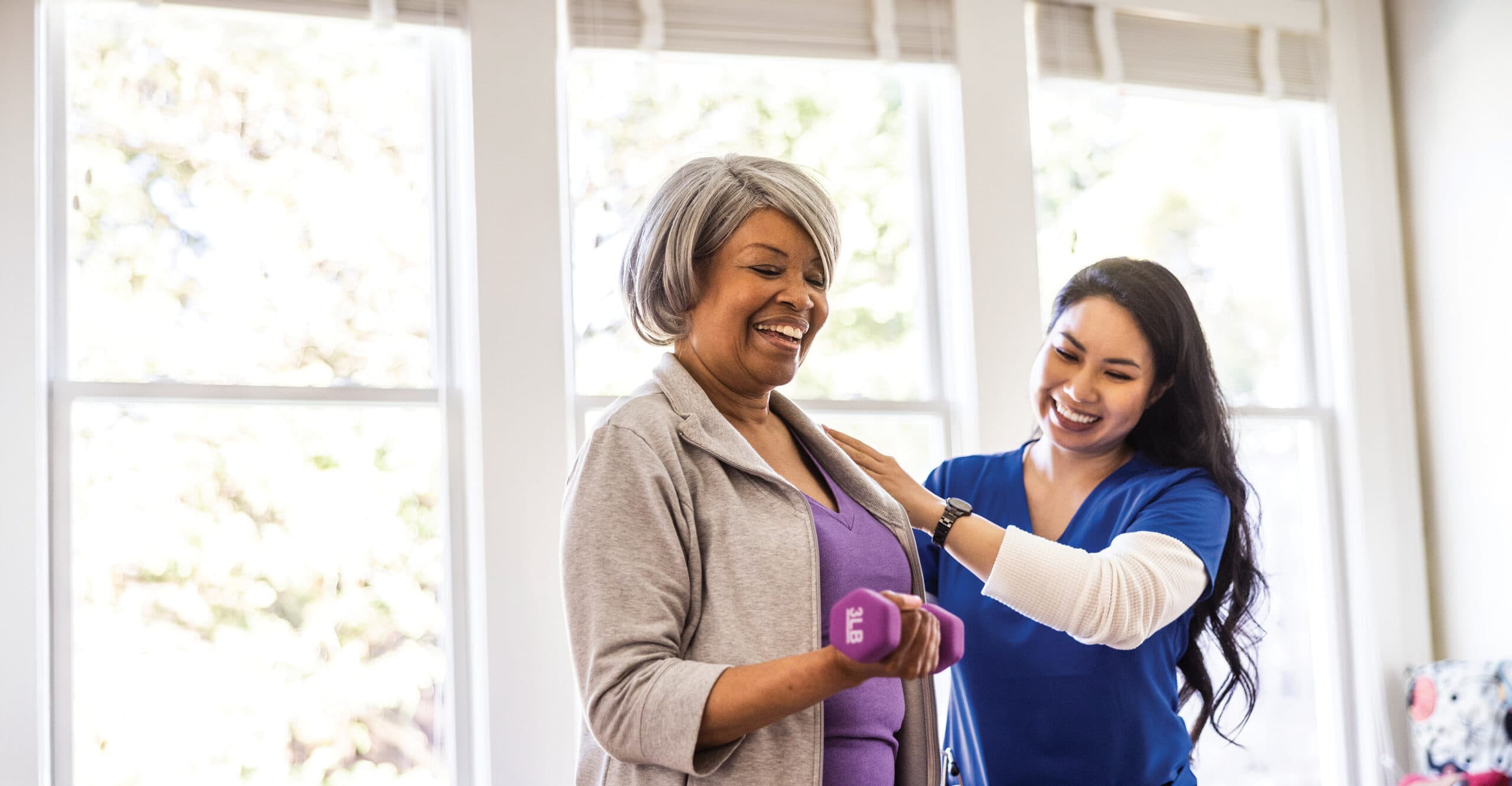 At home nurse helping an older woman with physical therapy at home.